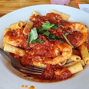 rigatoni with marinara sauce and shrimp on restaurant table