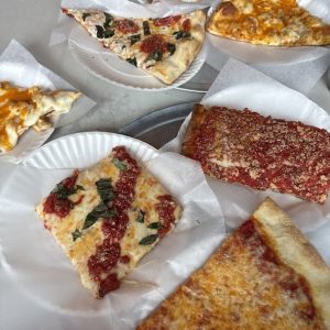 variety of pizza by the slice options on a table