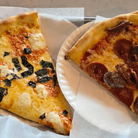 pizza by the slice served on paper plates