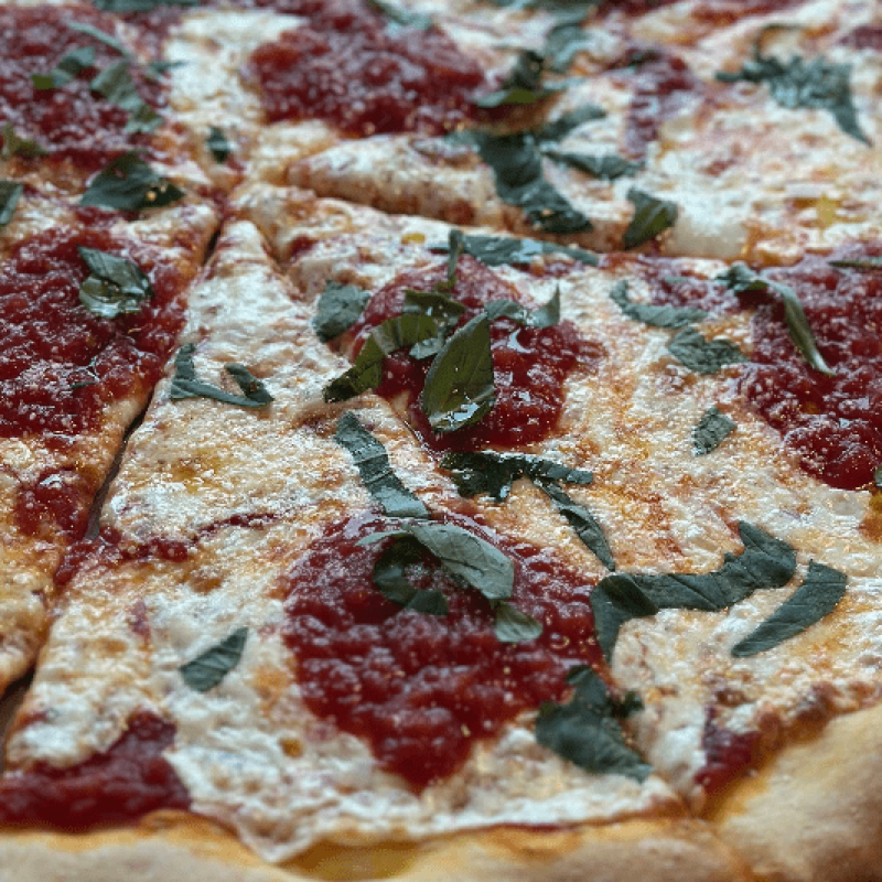 close up of pizza with homemade tomato sauce and basil